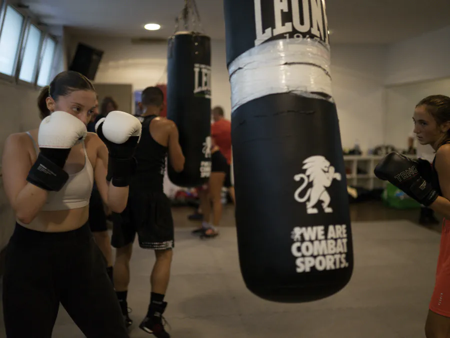 In guardia con i guantoni bianchi, tra i sacchi della sala Boxe