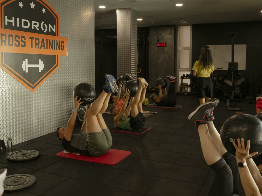 Addominali con la palla medica, sotto il logo della sala Cross Training