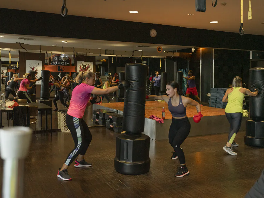Lezione ai sacchi da boxe in sala, con l’insegna Hidron in fondo